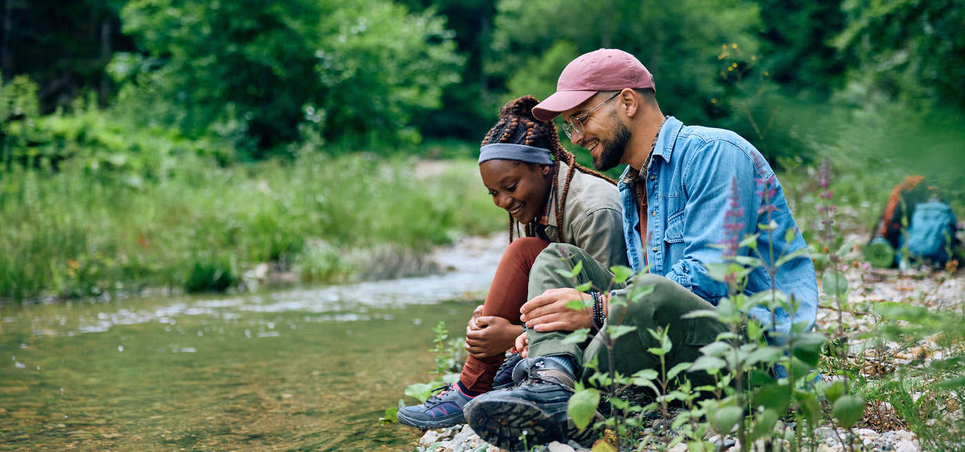 Couple taking a break from hike near creek